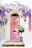 A beautifully composed doorway in Bowes Park is bathed in soft, natural light, perfectly capturing the emotion of a new home celebration. At its centre is a gently glowing pink front door, its paintwork smooth yet subtly weathered, suggesting a place of character and warmth. Surrounding it, the walls are whitewashed to a creamy hue, catching sunbeams that filter down through an impressive canopy of wisteria. The wisteria trails overhead in cascading clusters of lavender and pale purple, their flowers gathered along delicate stems that create a curtain-like effect above the threshold, as though nature itself is decorating the entrance. On the doorstep rests a generous floral display in a simple grey bucket, filled with lush white and soft cream roses. Their petals are full and rounded, some blooms just opening, others in perfect, cupped formation, all cushioned by muted green foliage that adds depth and contrast. Around the base of the bucket, a soft pink ribbon is tied in a graceful bow, its colour echoing the front door and pulling the whole scene into gentle harmony. You can imagine this arrangement being carried along nearby streets by a florist who knows Bowes Park well, delivering it as a housewarming surprise to celebrate someone's move into a new property off Green Lanes. The overall mood is calm yet hopeful, a serene blend of pastel tones and natural textures. It feels like a visual blessing for new beginnings: flowers, light, and colour combining to say, with quiet sincerity, welcome to your new home.